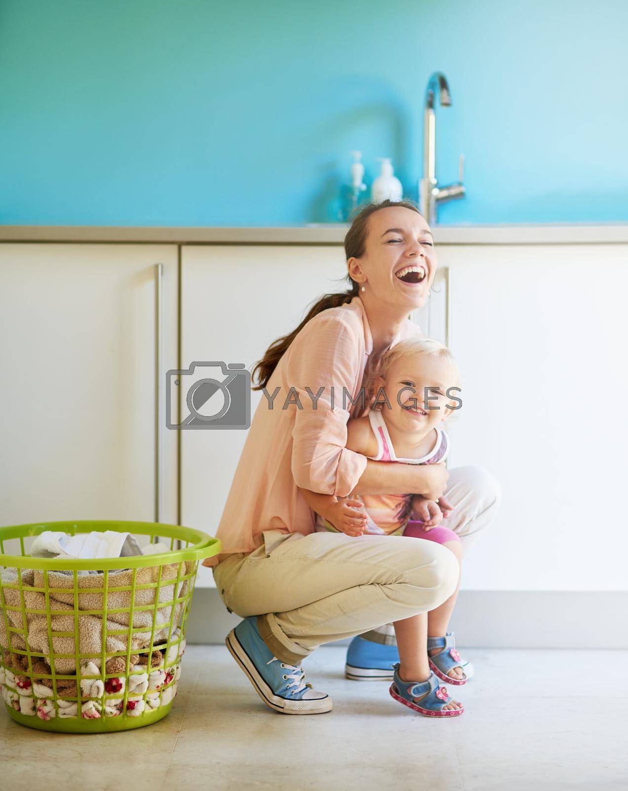 Shot of a mother and daughter having fun while doing housework.