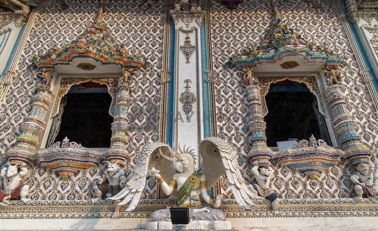 Bangkok, Thailand. Feb - 10, 2022 : Elaborate sculptures of monsters decorated and windows side exterior the chapel of The Pariwas Ratchasongkram temple. No focus, specifically.