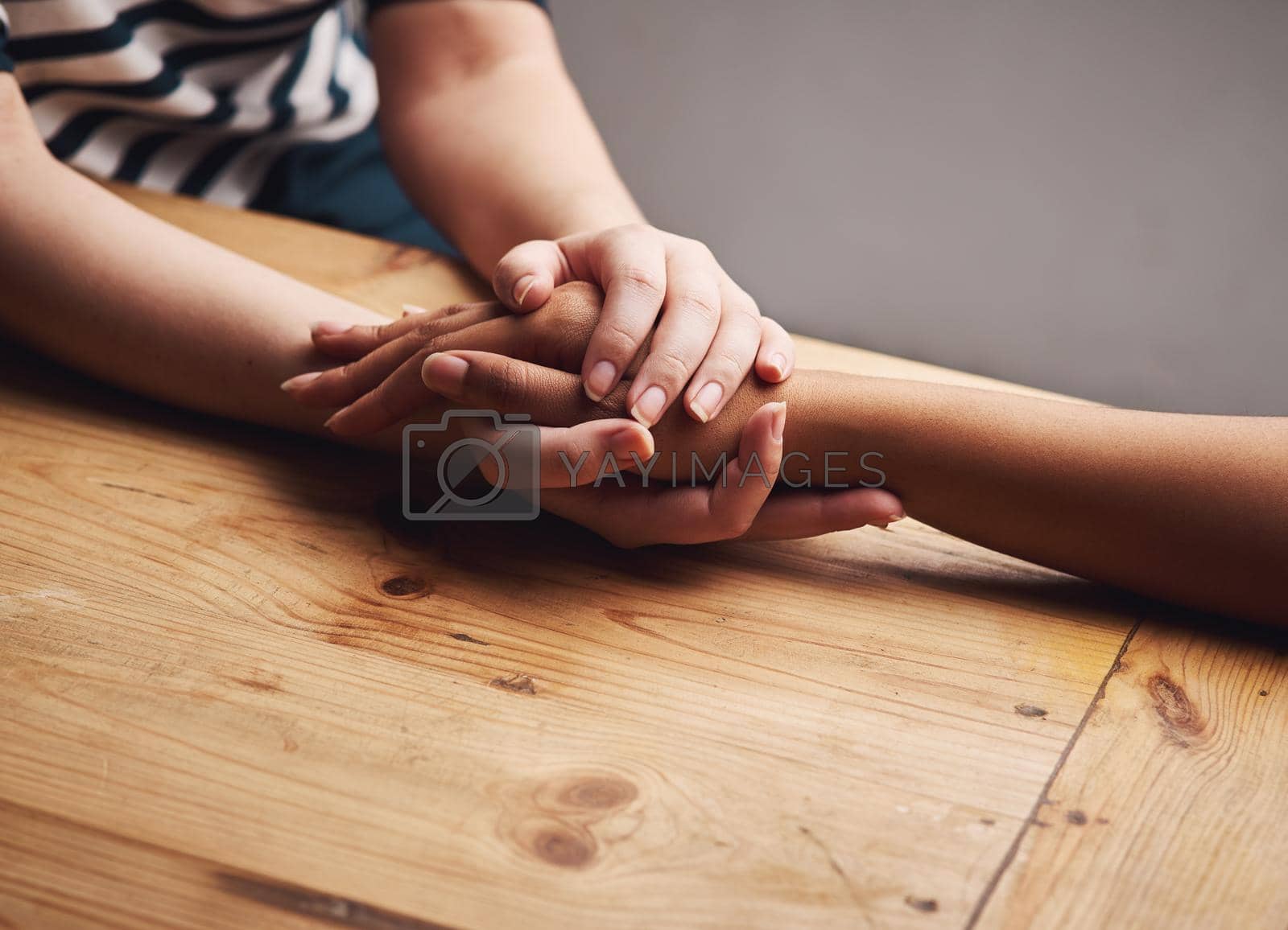 Shot of two people holding hands in comfort.