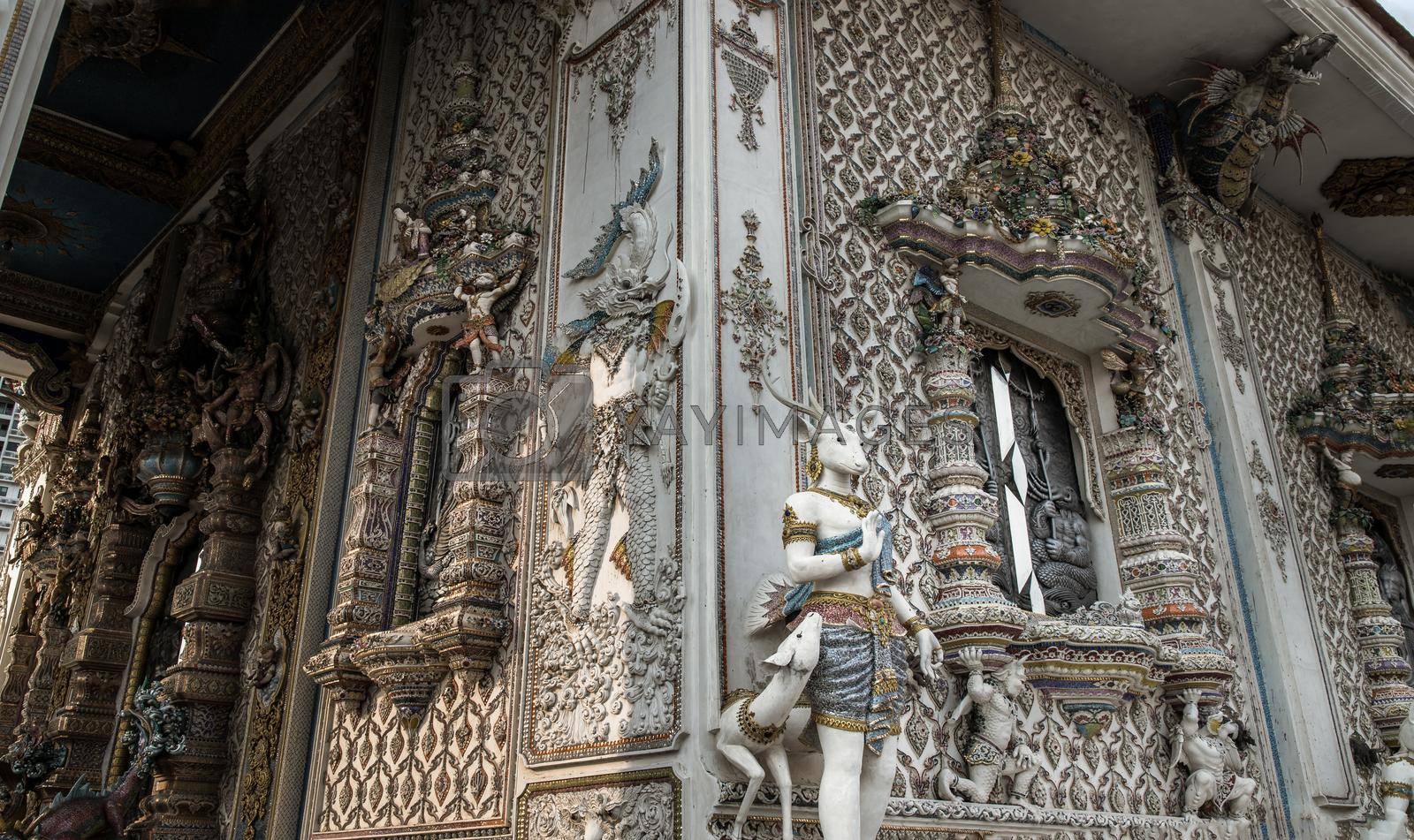 Bangkok, Thailand. Feb - 10, 2022 : Elaborate sculptures of monster is made of bricks and mortar, decorated with various colored glazed tiles at the chapel of The Pariwas Ratchasongkram temple. Selective Focus.