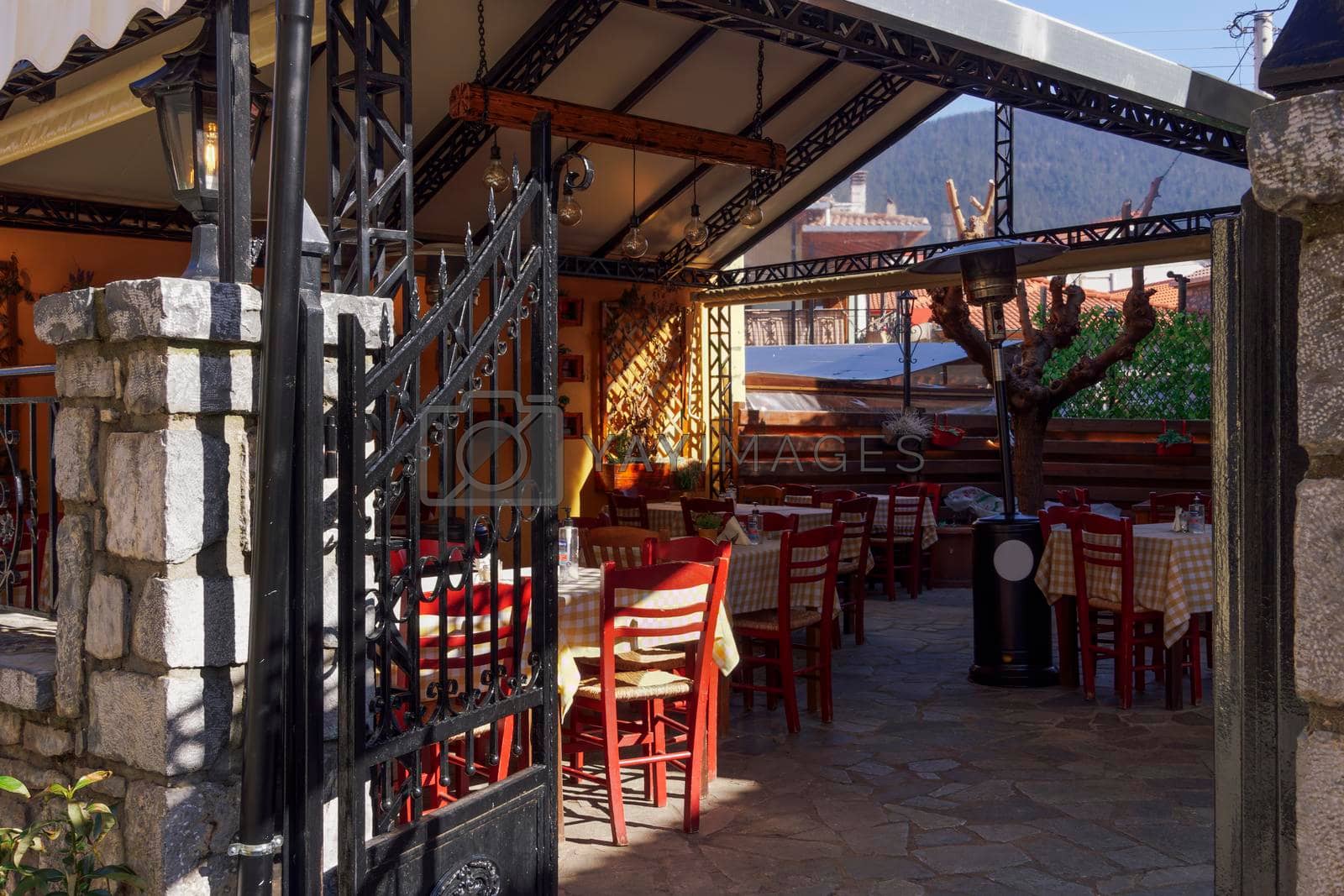 Vytina, Greece - February 25 2022: Greek empty tavern courtyard with chairs and tables in Vytina, Arcadia Peloponnese.