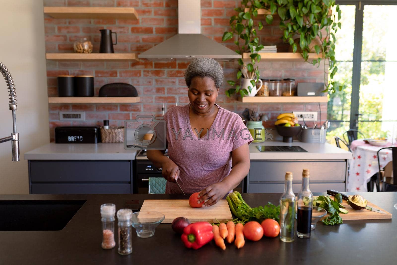 Royalty free image of Happy african american senior woman cooking in kitchen by Wavebreakmedia