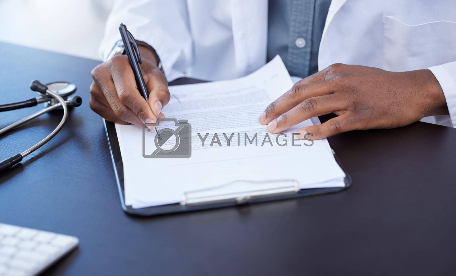 Royalty free image of Going over some paperwork. Closeup shot of a male doctor filling out paperwork. by YuriArcurs