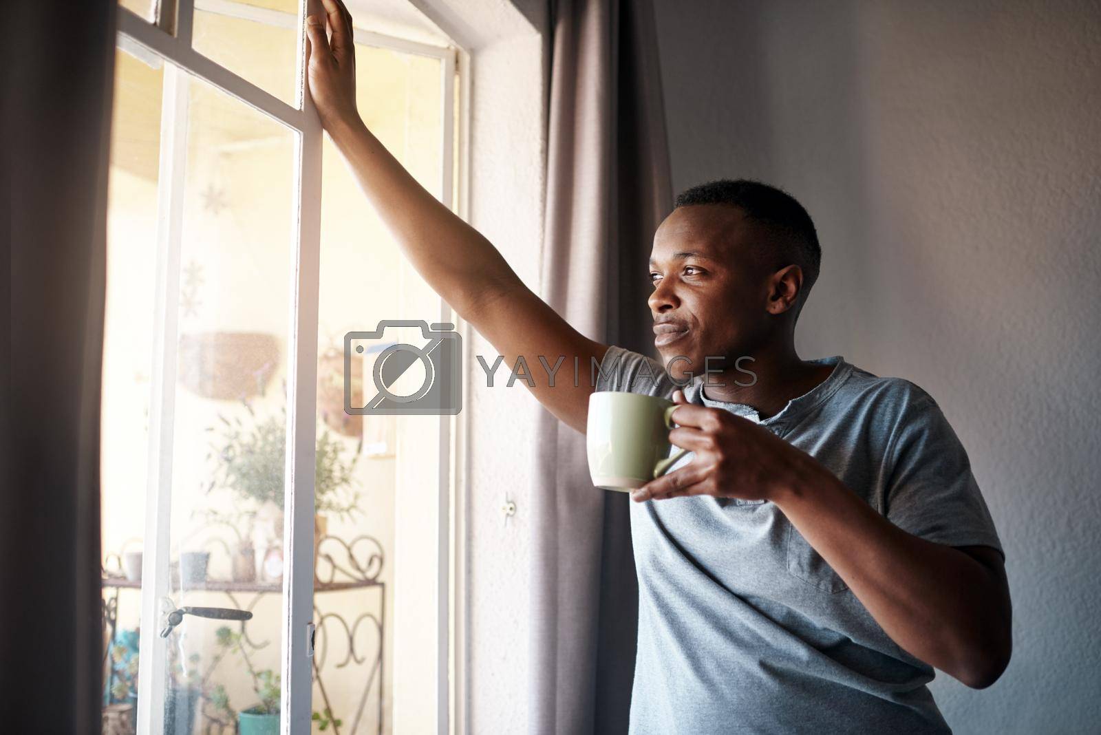 Royalty free image of I wonder what I should do today. Cropped shot of a handsome young man standing and looking contemplative in his bedroom while enjoying a cup of coffee. by YuriArcurs