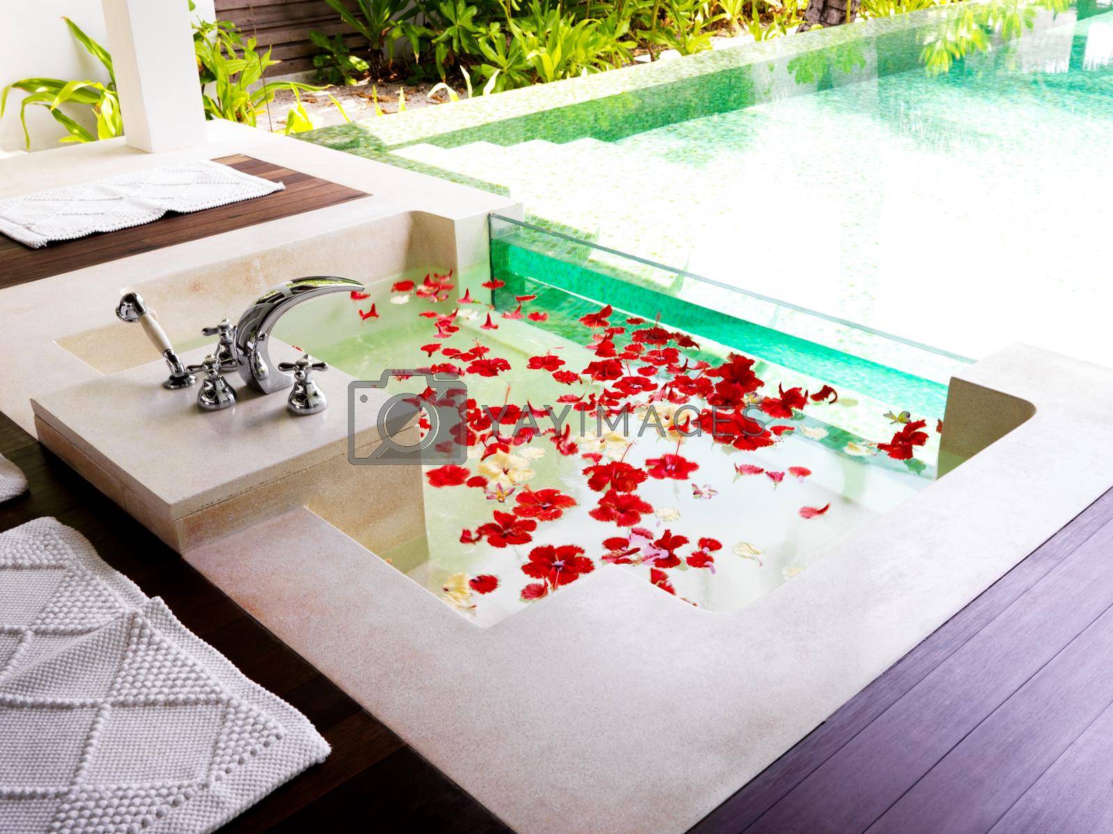 Modern bathroom with bath tub full of flower petals at a spa resort.