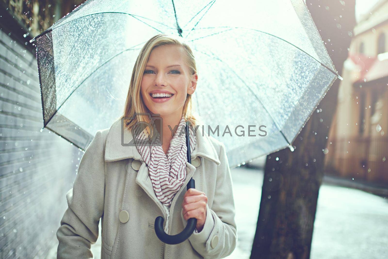 Cropped portrait of an attractive young woman walking in the rain.