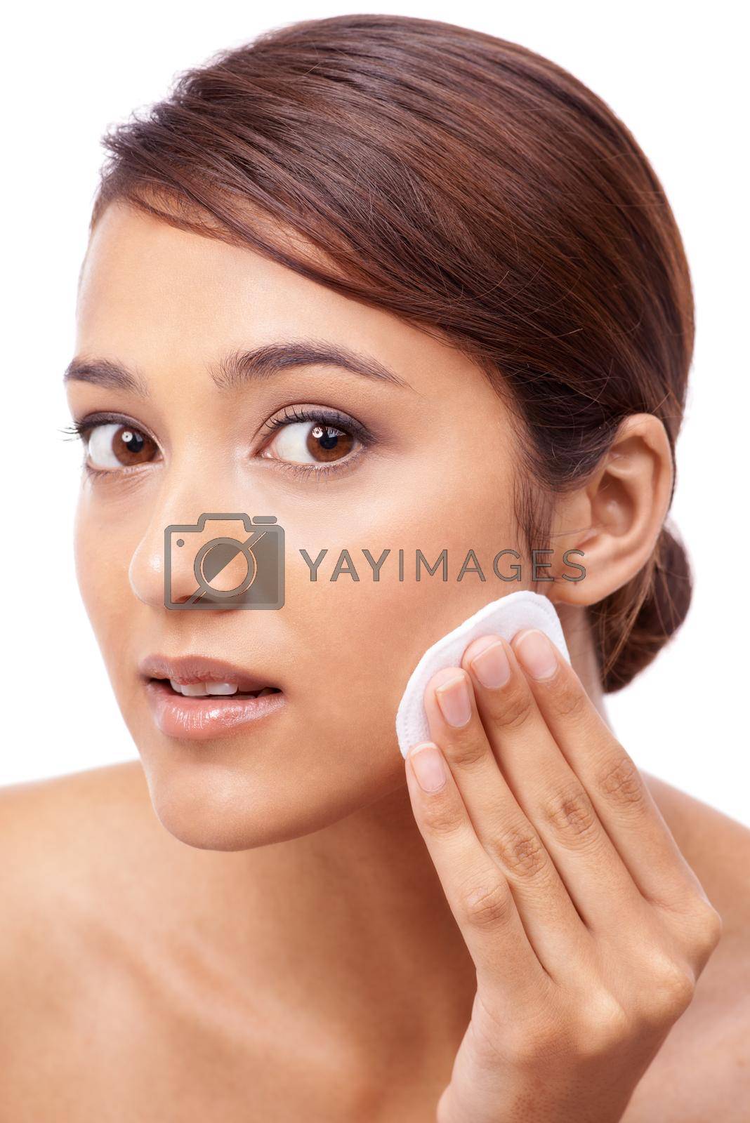 Royalty free image of Make sure you take off all your make-up before you go to bed. Portrait of a beautiful young woman moisturizing her face. by YuriArcurs