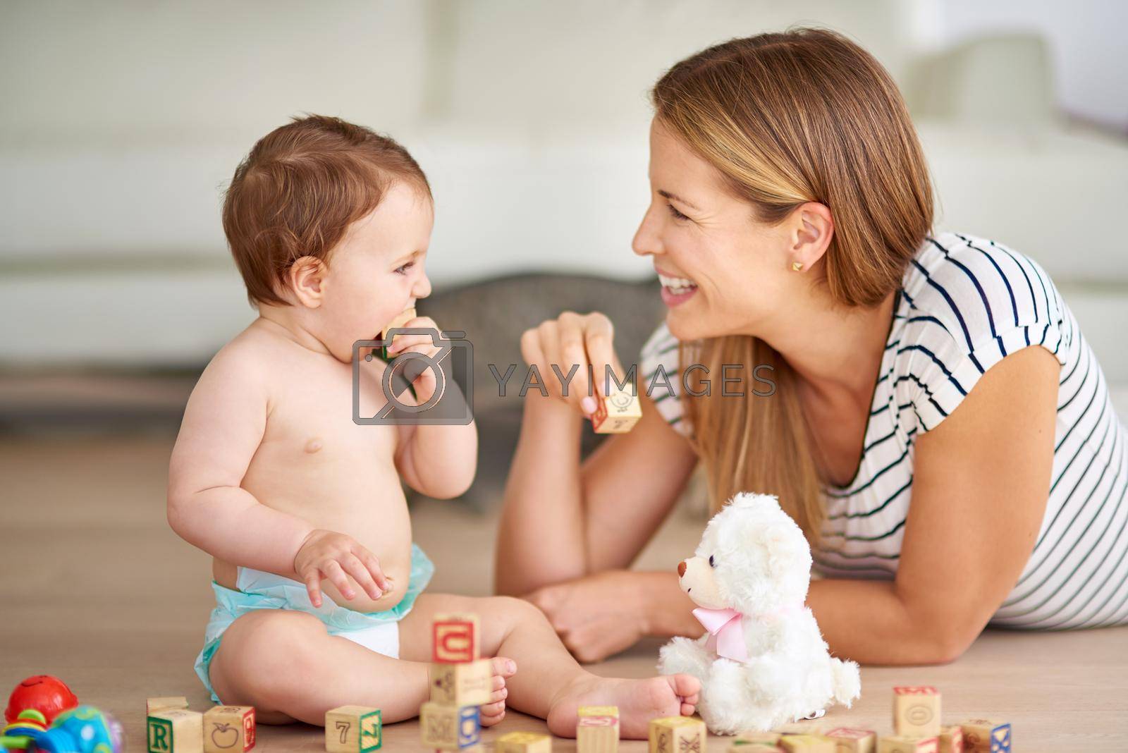 Shot of an adorable baby girl and her mother playing with wooden blocks at home.
