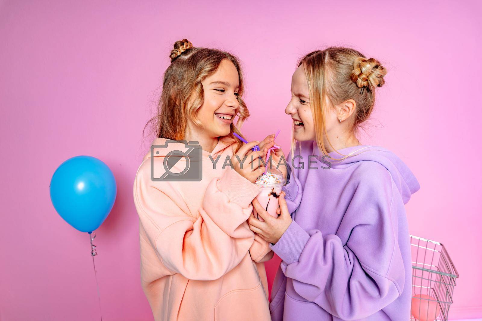 Two beautiful attractive funny joyful cheerful relaxed carefree girls dressed in casual fashion clothes isolated on hot pink background.