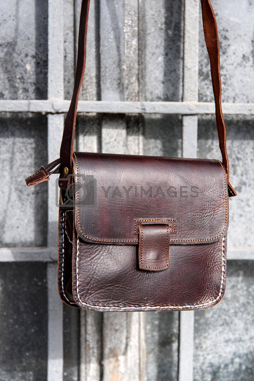 Royalty free image of close-up photo of brown leather messanger bag. outdoors photo by Ashtray25