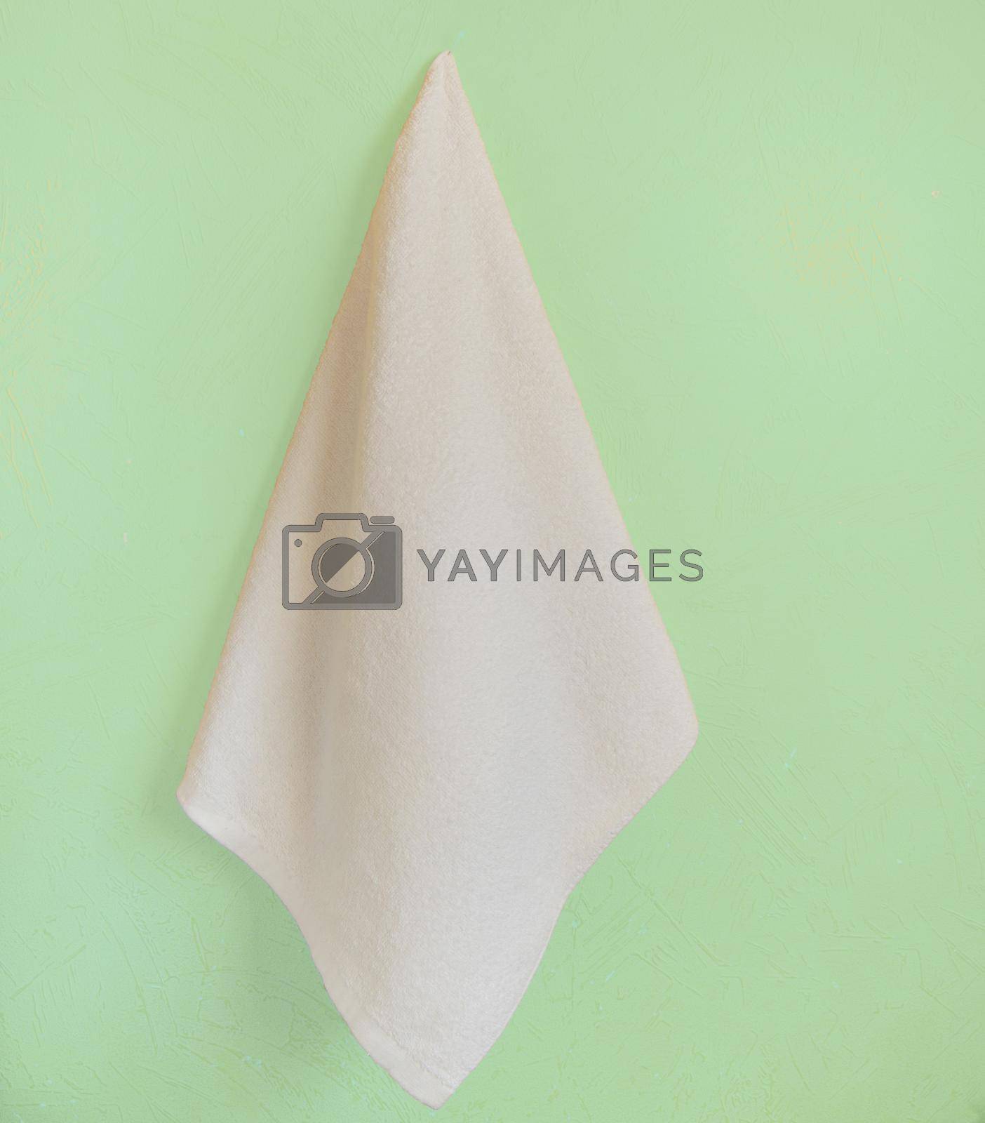 White Spa towel hanging on a yellow wall.