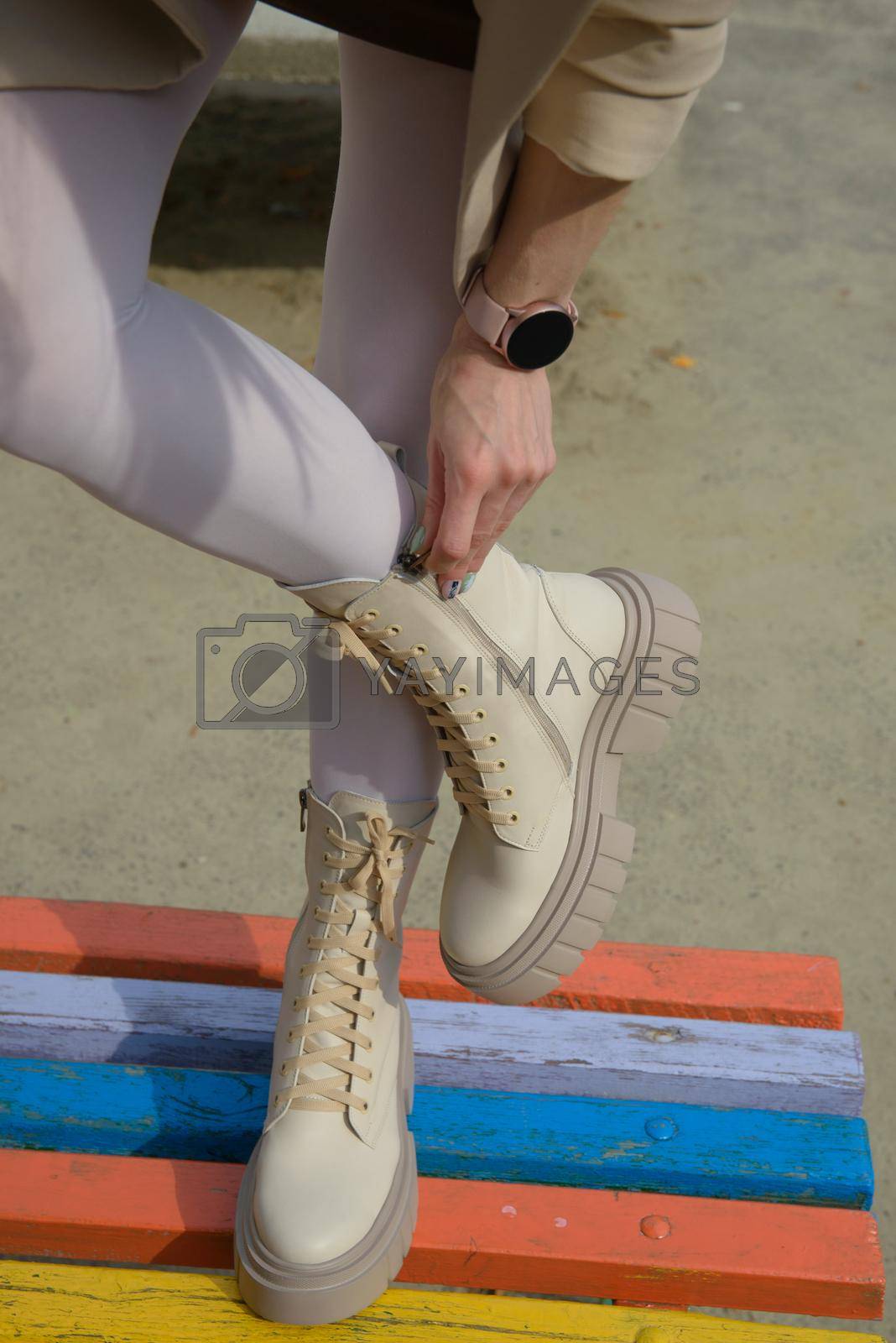 Female legs wearing white fashion boots with laces.