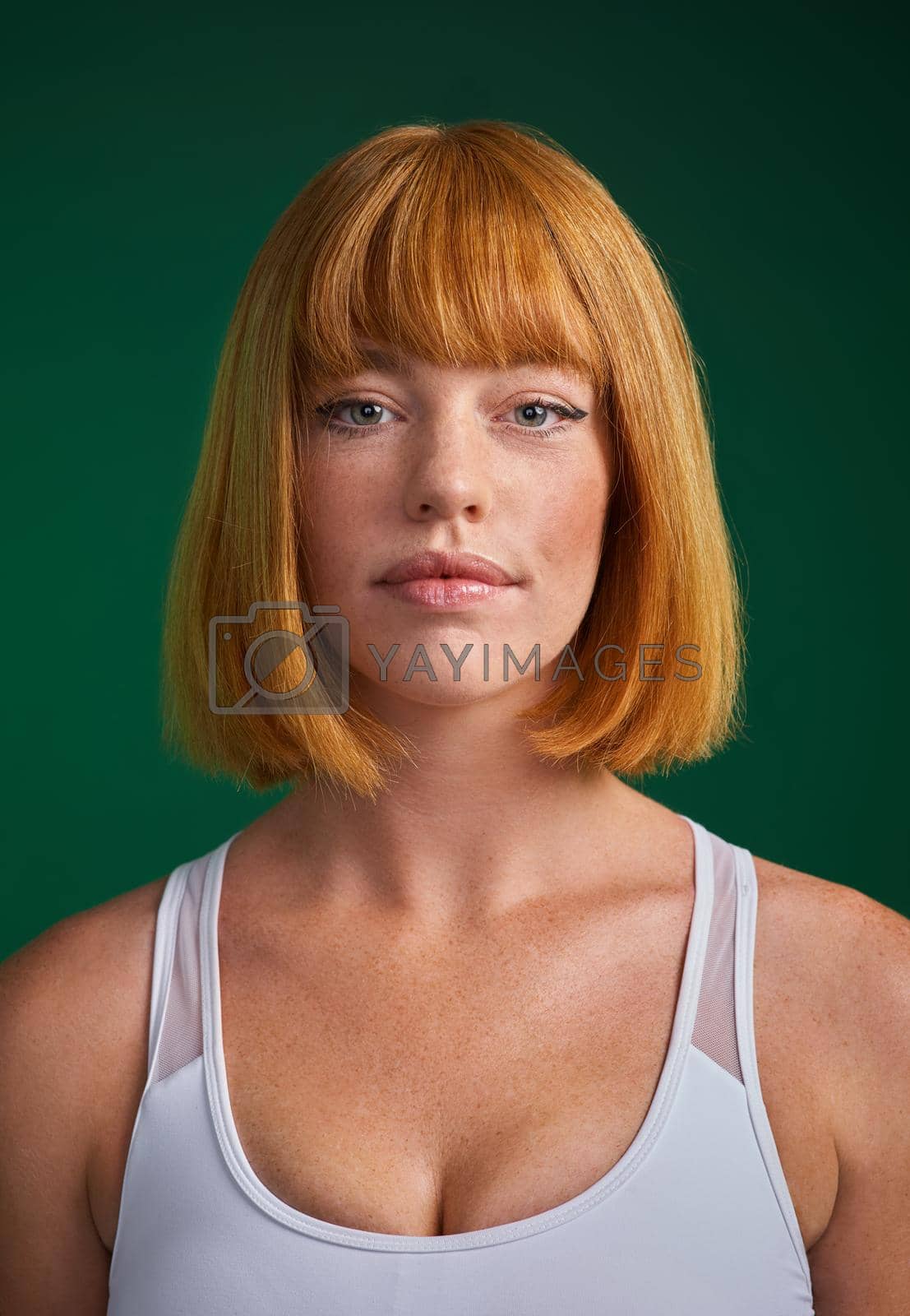 Cropped portrait of an attractive young sportswoman standing alone against a green background in the studio.