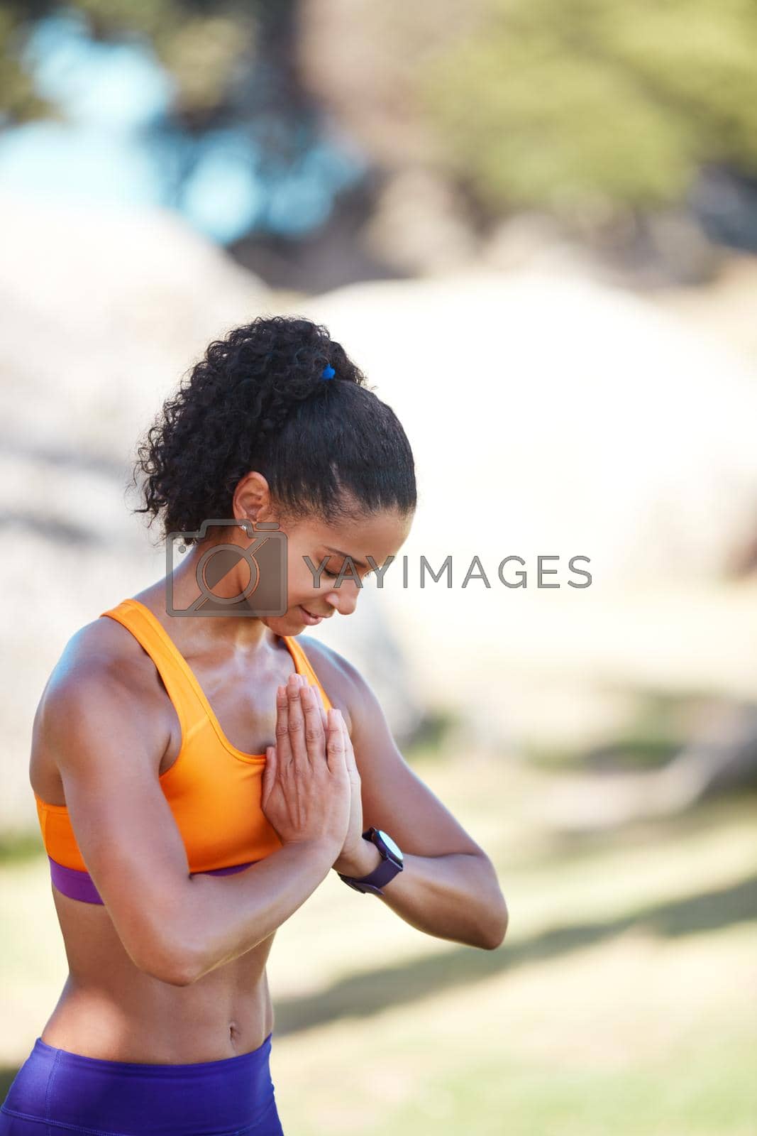 Shot of an attractive young woman practising yoga at a park.