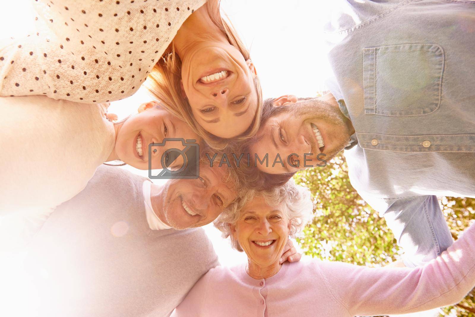 A low angle portrait of a happy family standing in a huddle.