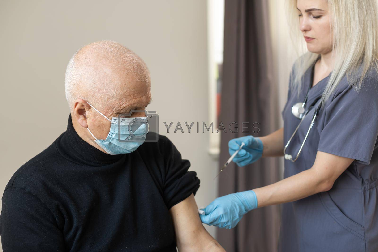 Royalty free image of elderly man getting coronavirus vaccine by Andelov13