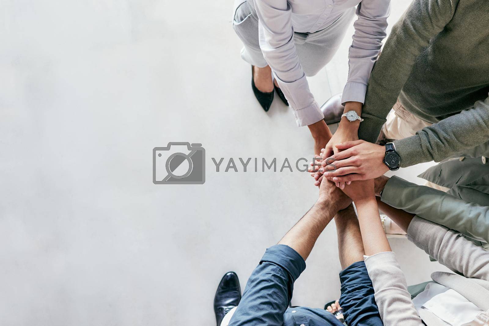 Royalty free image of Youve got to get up every morning with determination. Shot of a group of unrecognizable businesspeople stacking their hands at work. by YuriArcurs