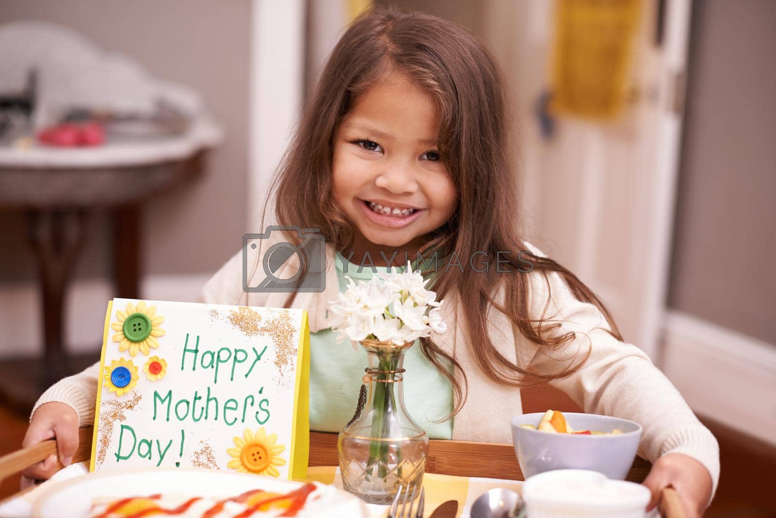 Royalty free image of A present for Mom. A little girl bringing her mom breakfast in bed on Mothers Day. by YuriArcurs