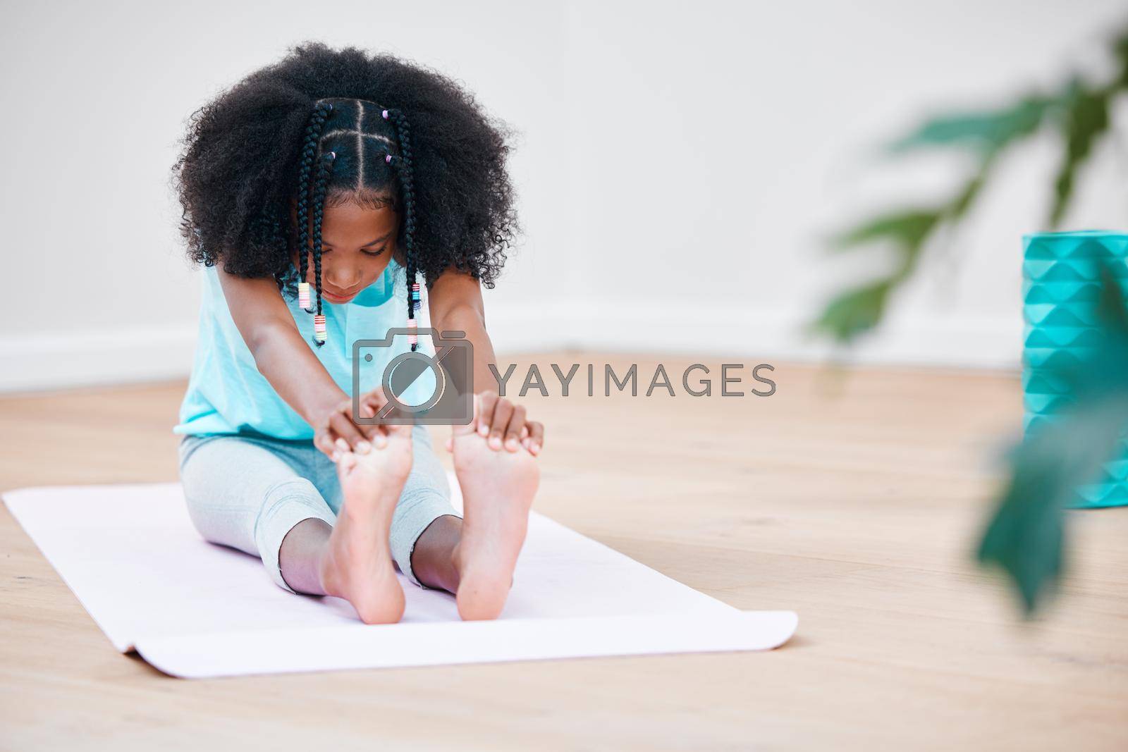 Shot of a young girl practicing yoga at home.