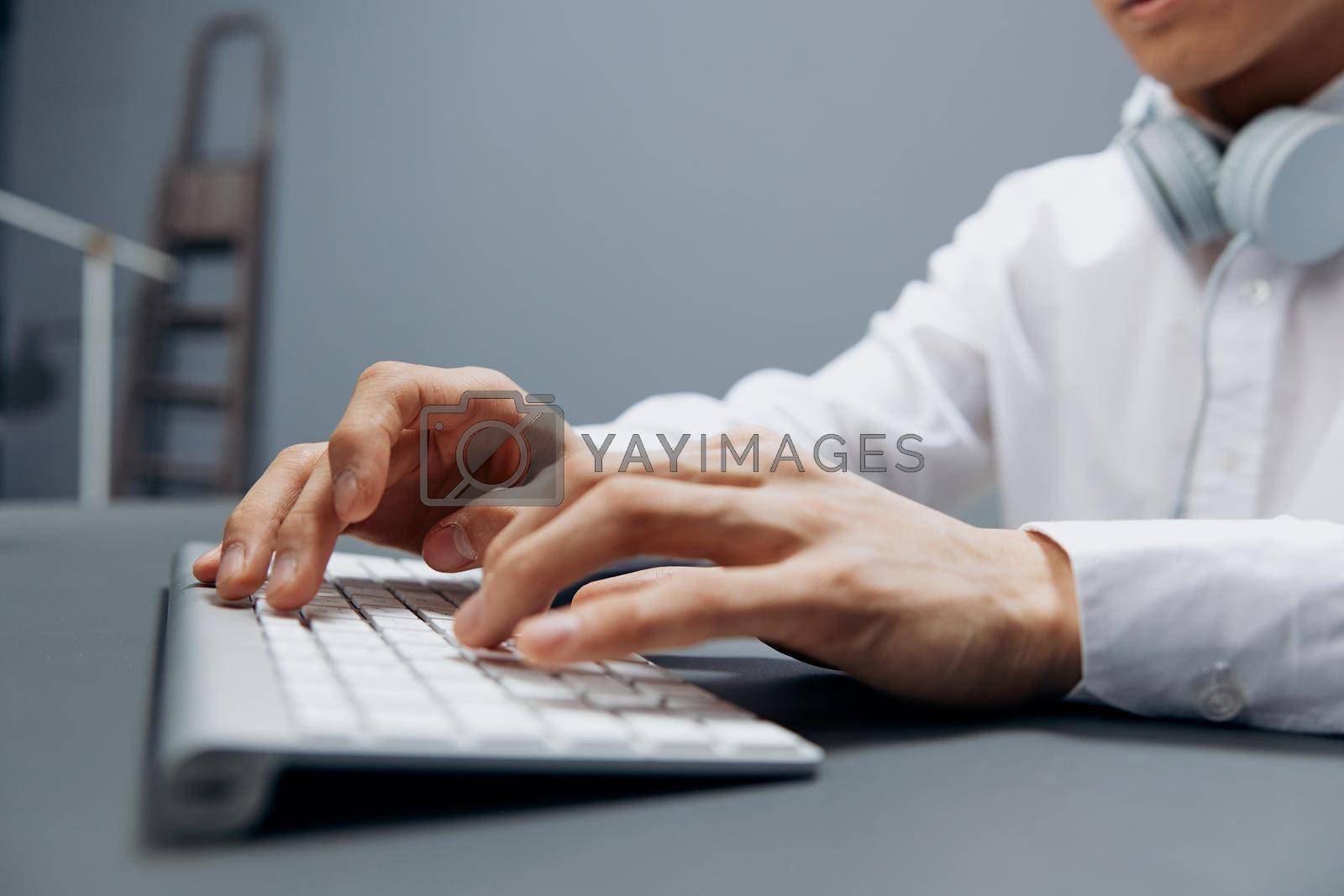 Royalty free image of worker in headphones hands on keyboard office work close-up isolated background by SHOTPRIME