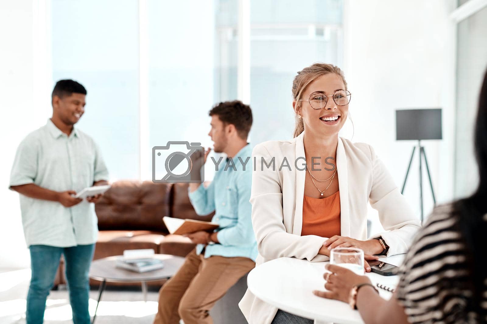 Royalty free image of Its an awesome work environment. Cropped shot of a group of young businesspeople socializing in their office. by YuriArcurs