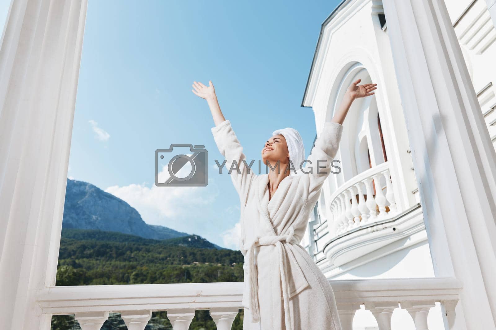 Royalty free image of woman with a towel on my head in a white bathrobe staying on the balcony in a hotel Perfect sunny morning by SHOTPRIME