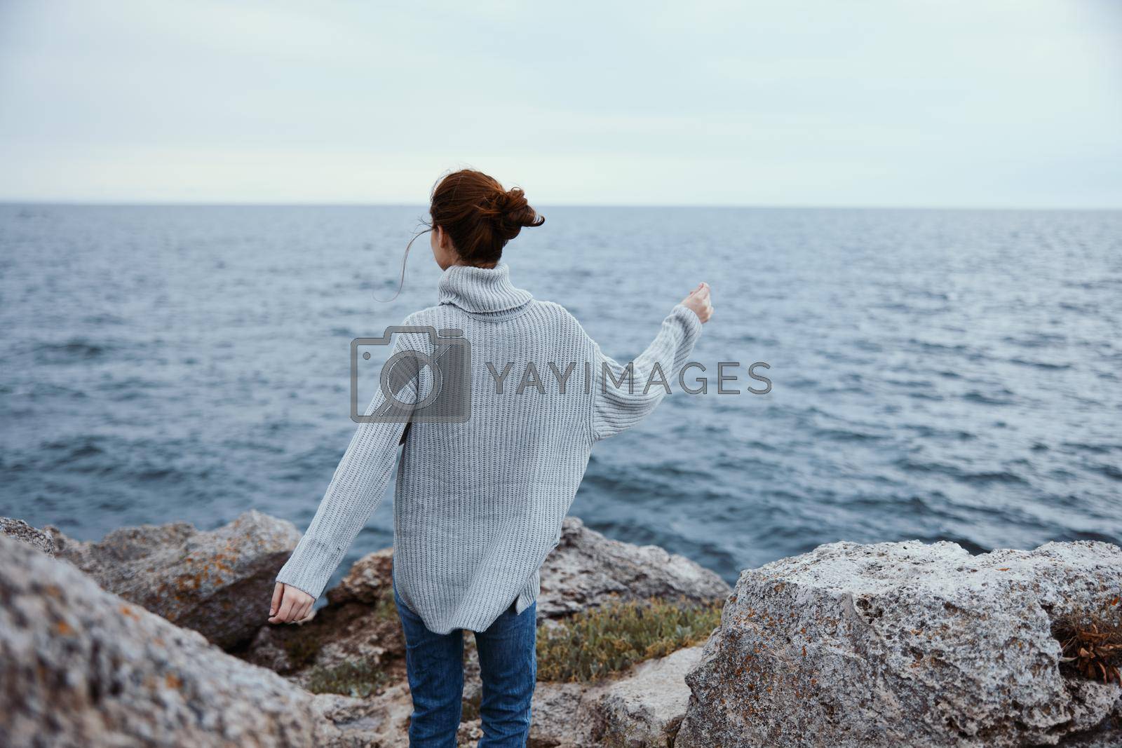 pretty woman beach tourism cloudy weather stone coast female relaxing back view. High quality photo