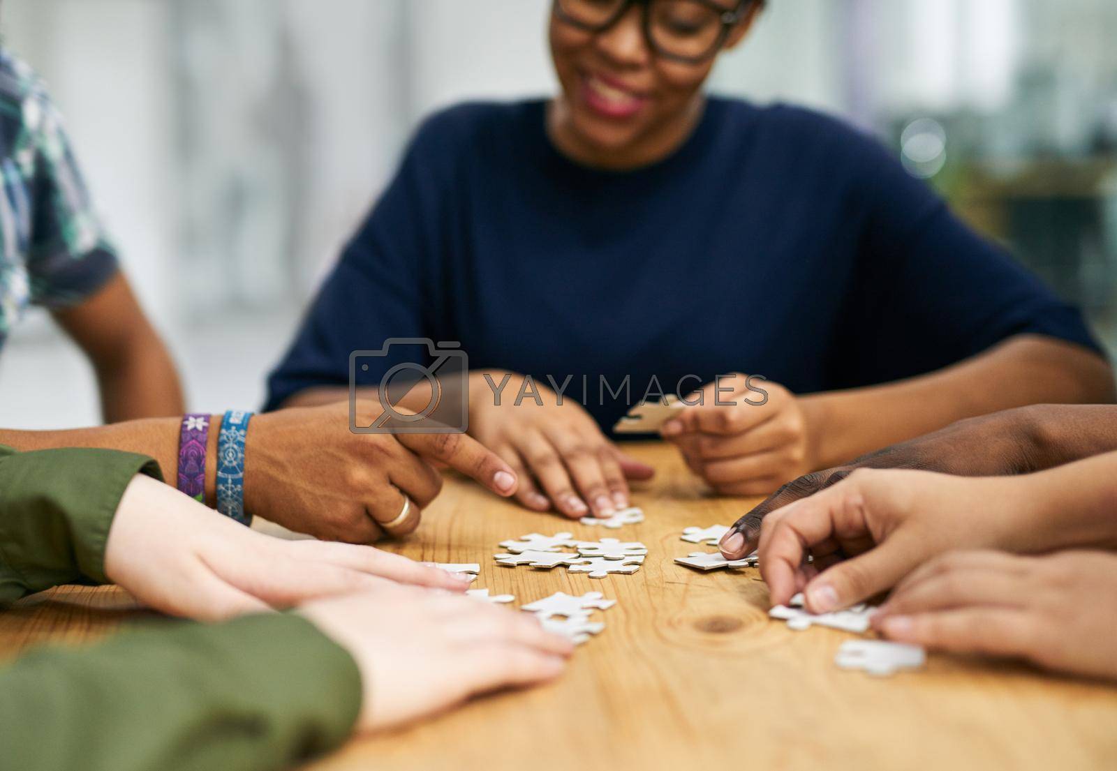 Shot of a group of people building a puzzle together.
