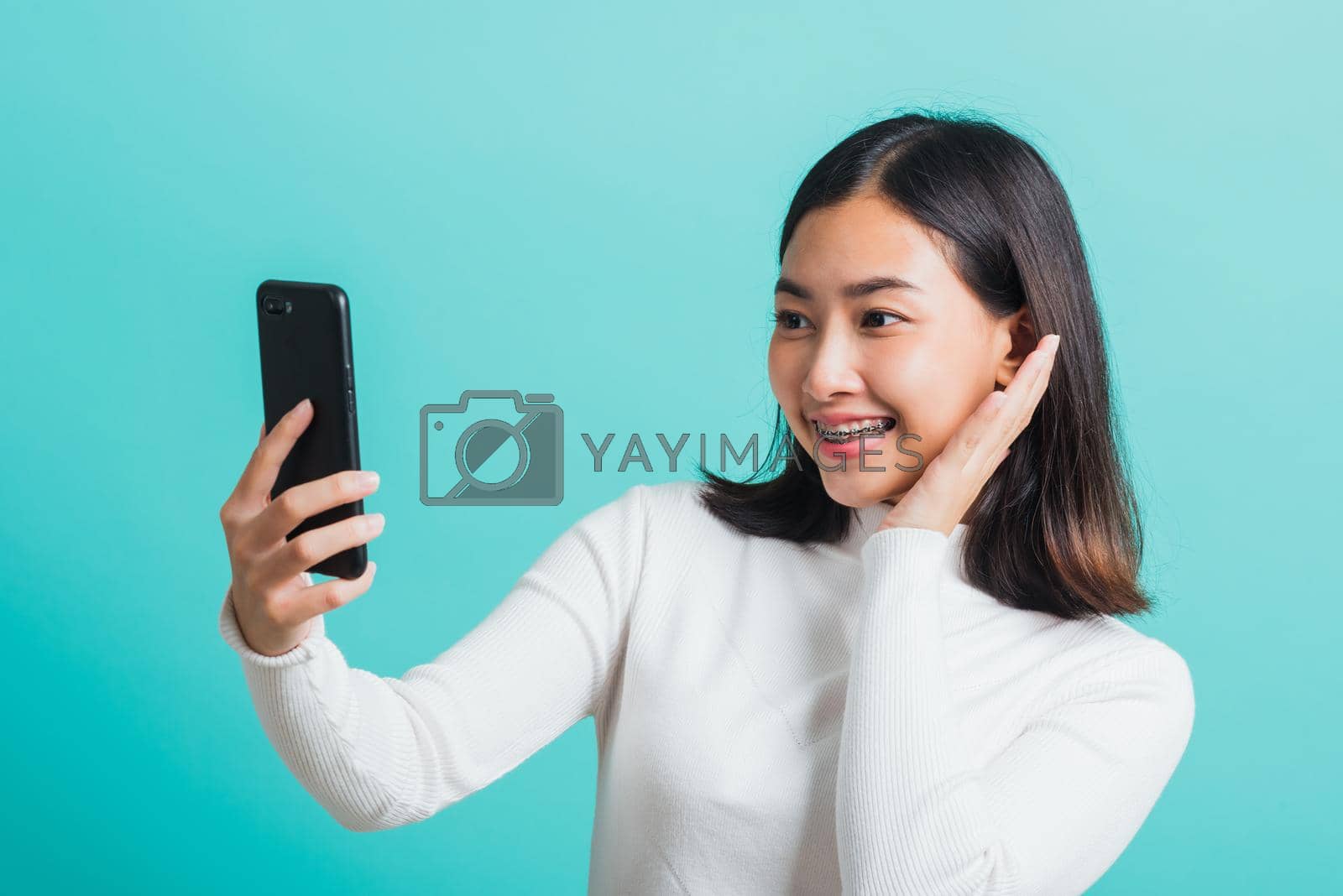 Royalty free image of woman smile she using a smartphone to selfie photo by Sorapop