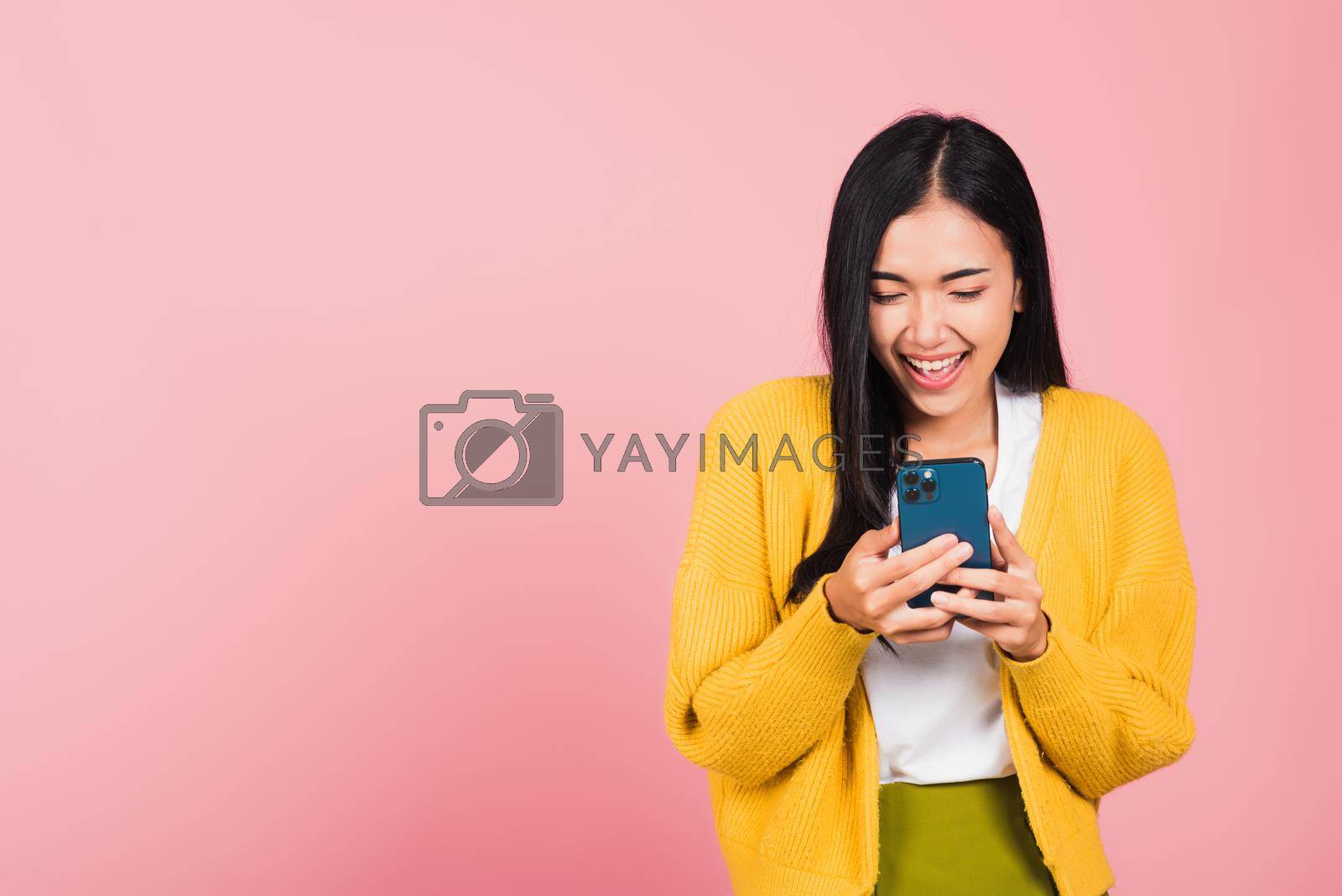 Royalty free image of woman teen smiling excited   using smart mobile phone by Sorapop
