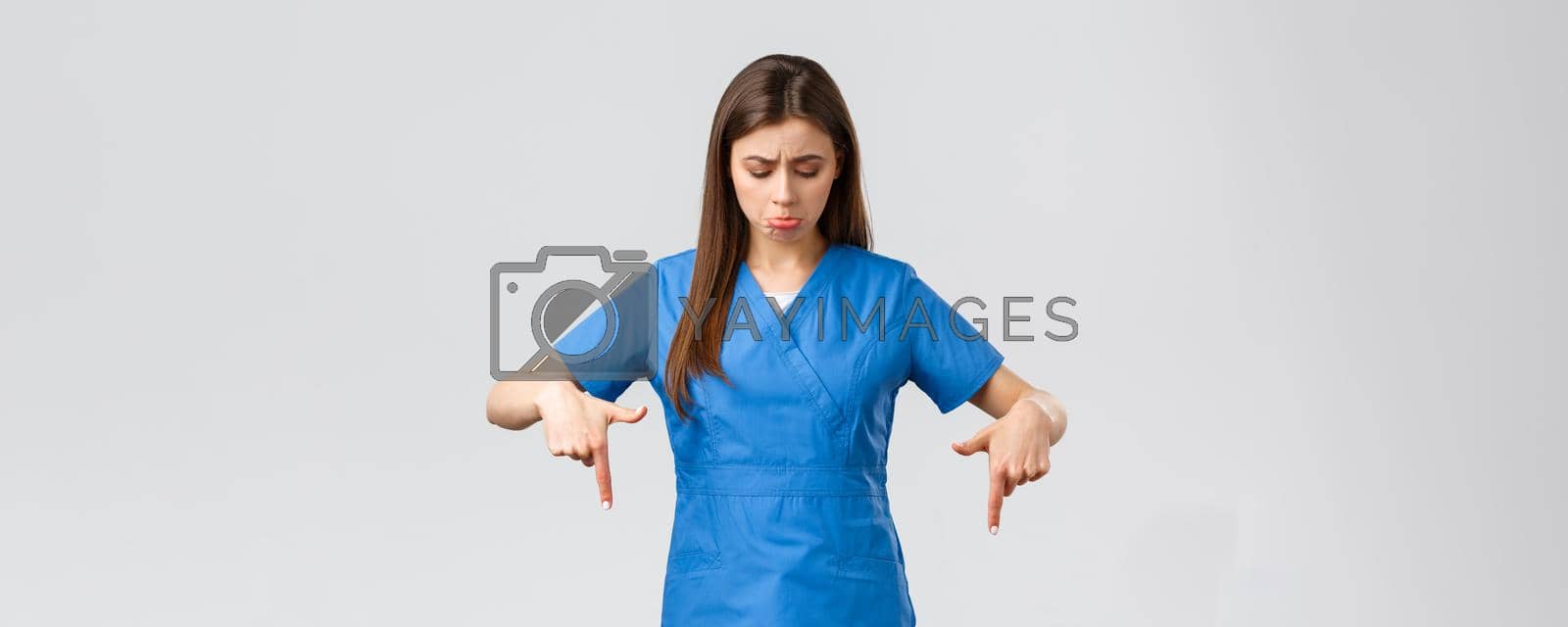 Healthcare workers, prevent virus, covid-19 test screening, medicine concept. Sad and distressed female nurse or doctor, intern sobbing and pouting from regret, pointing fingers down, look at banner.