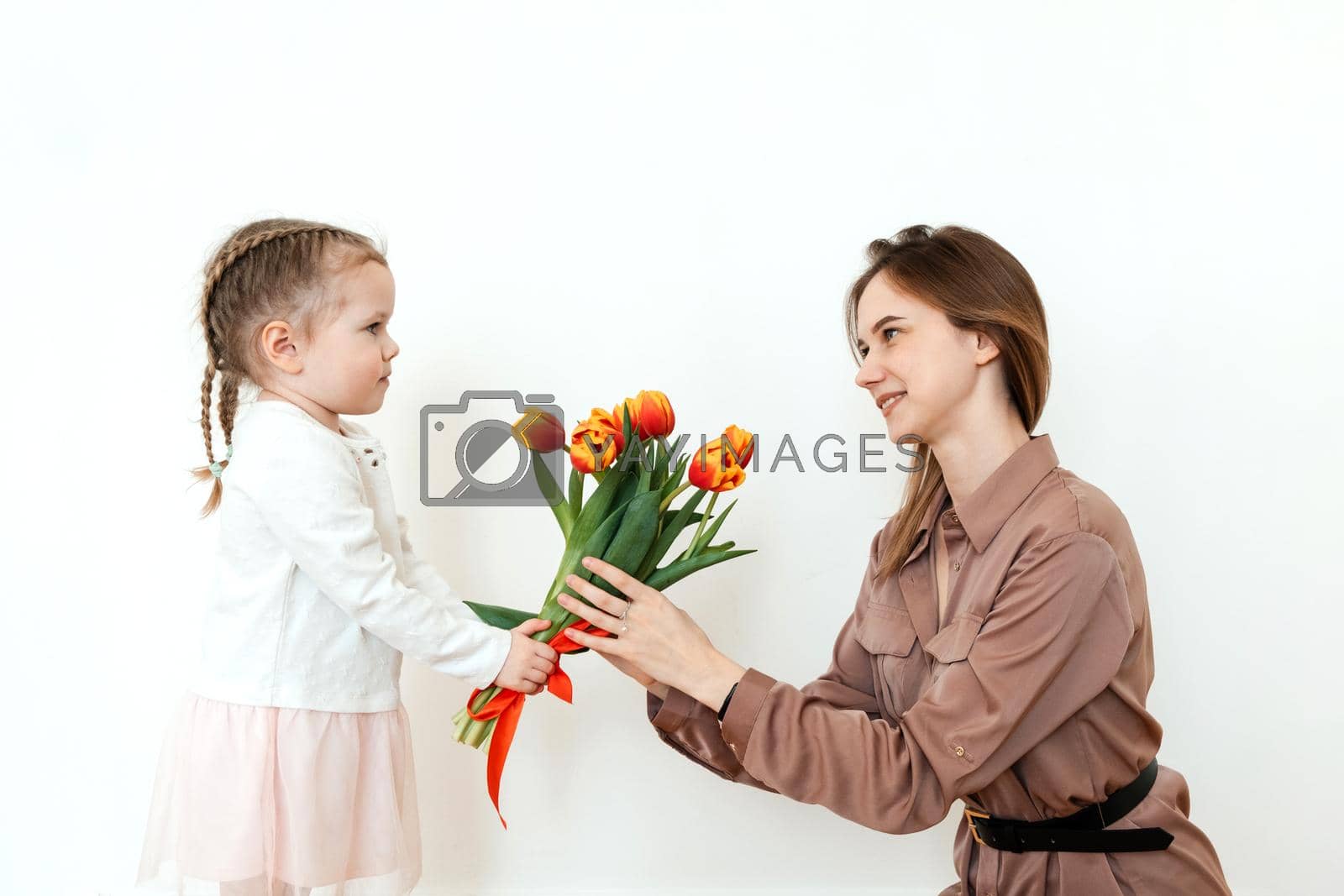 Happy daughter congratulates mom with tulips.