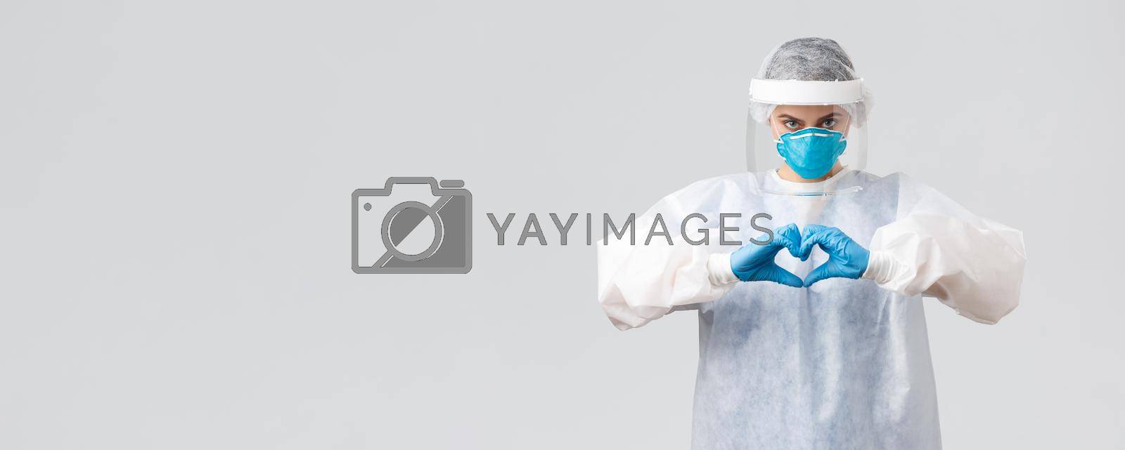 Covid-19, preventing virus, health, healthcare workers and quarantine concept. Doctor saving life patient from coronavirus pandemic, show heart sign, wear personal protective equipment, PPE costume.