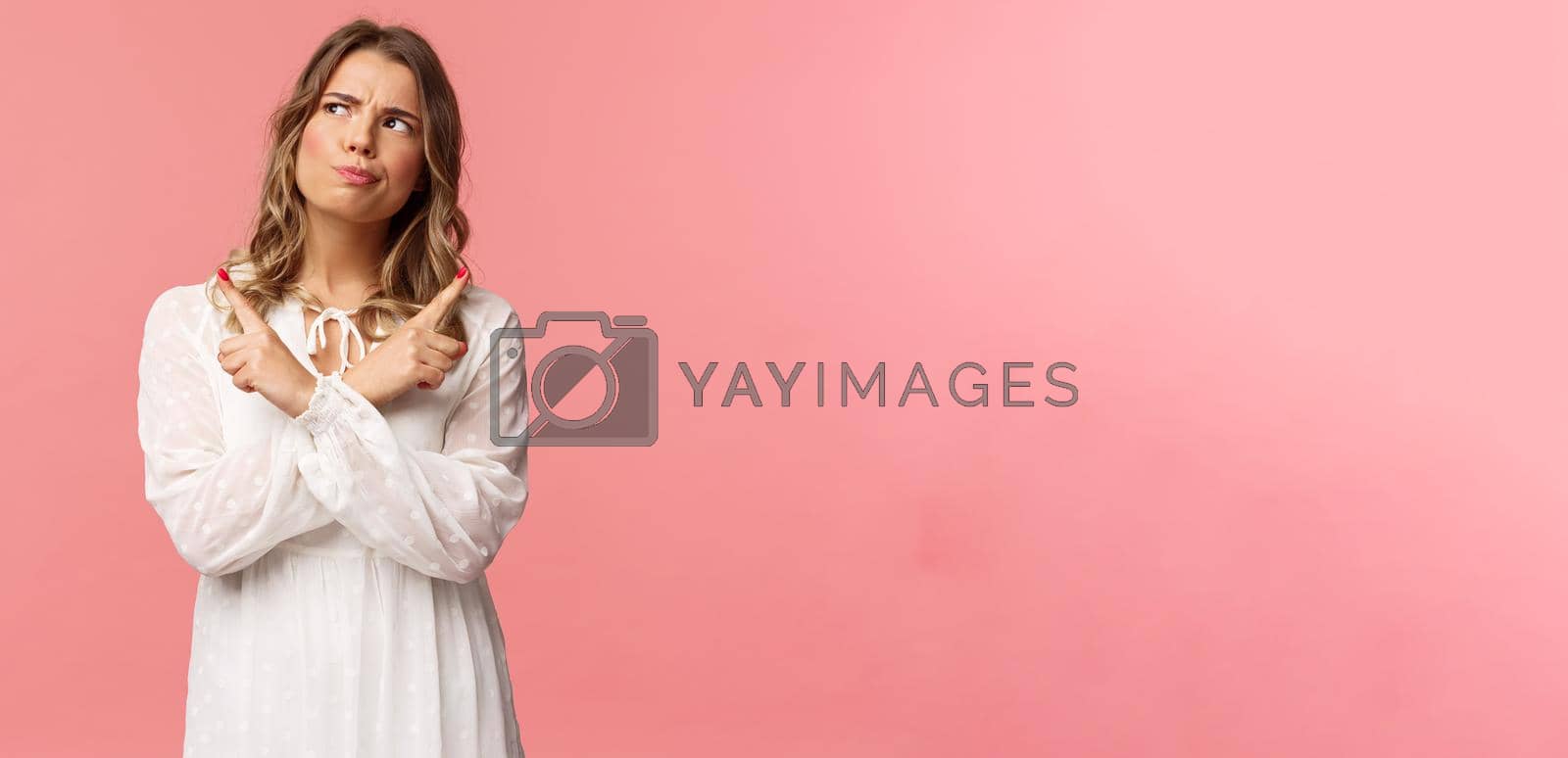 Beauty, fashion and women concept. Girl having problem with picking, making serious decision. Attractive blond woman look up thoughtful, smirk and grimacing, pointing sideways, point left and right.