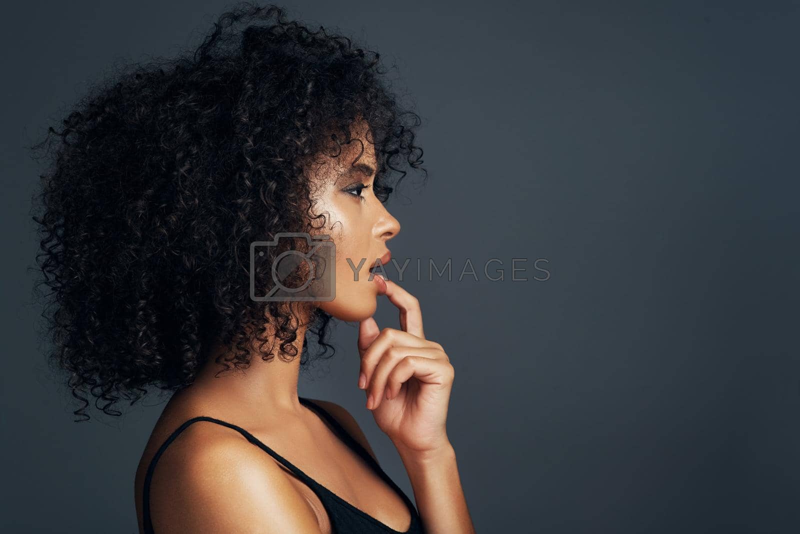 Studio shot of a beautiful young woman posing against a dark background.
