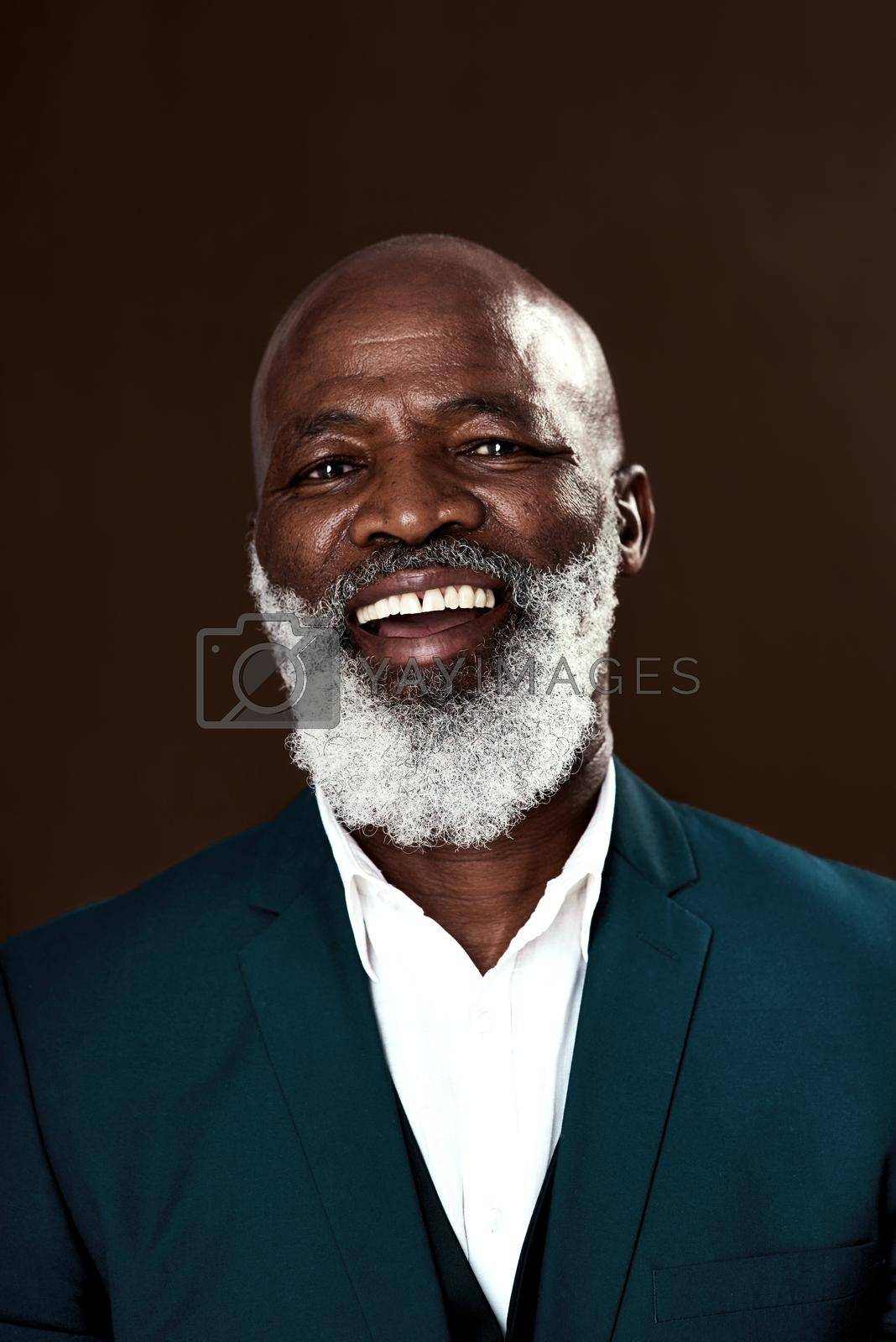 Royalty free image of Staying positive is whatll help you win. Studio shot of a mature businessman posing against a brown background. by YuriArcurs
