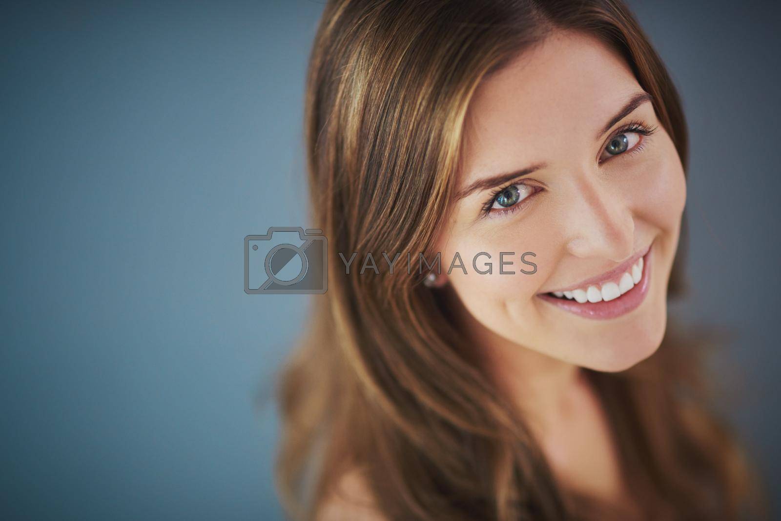 Royalty free image of Her smile is like no other. High angle studio shot of an attractive young woman smiling against a gray background. by YuriArcurs