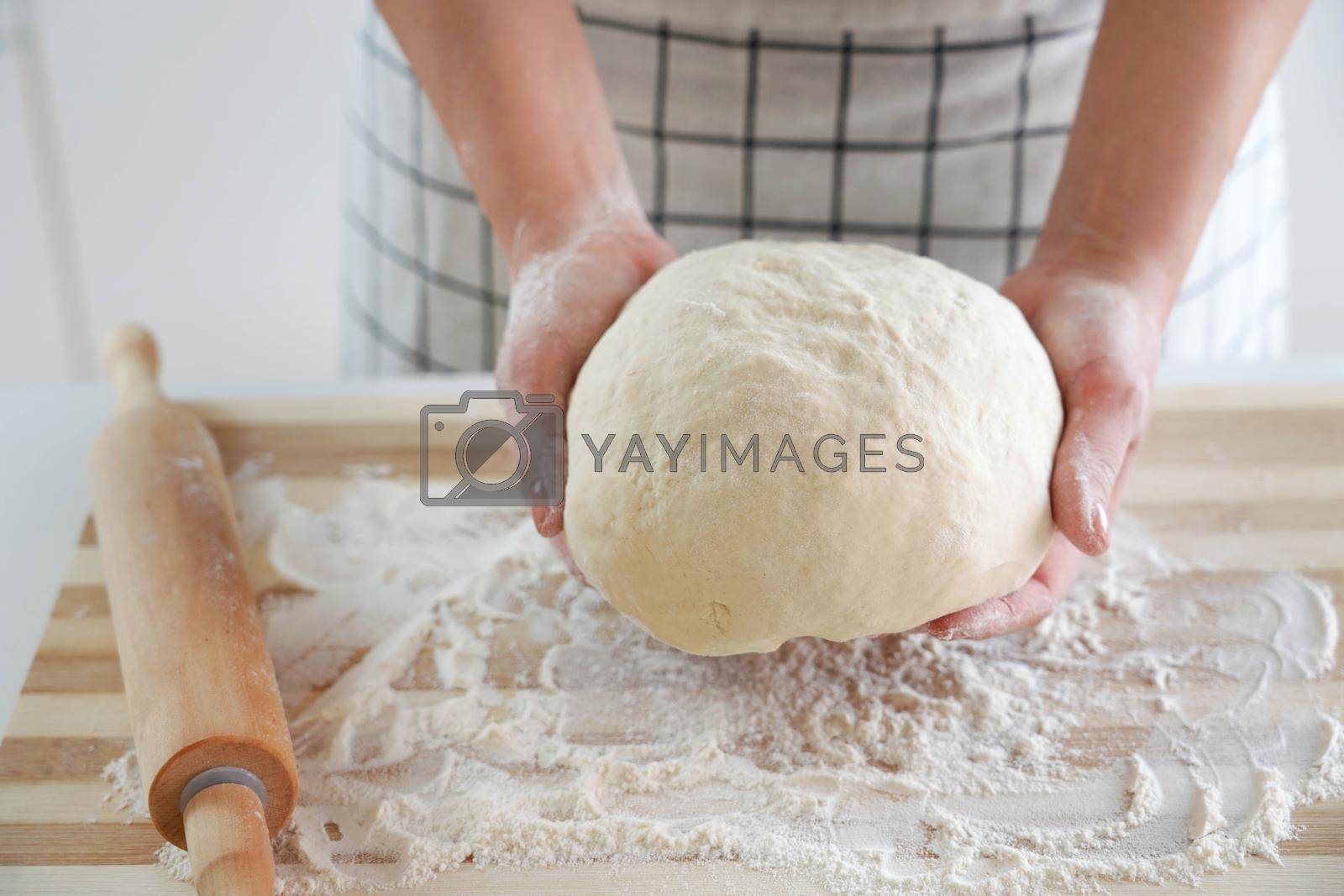 Royalty free image of Woman holds dough in her hands and shows at camera. Increasing price of wheat, flour and bread. Homemade bread preparation. Economic crisis. by sergio_monti