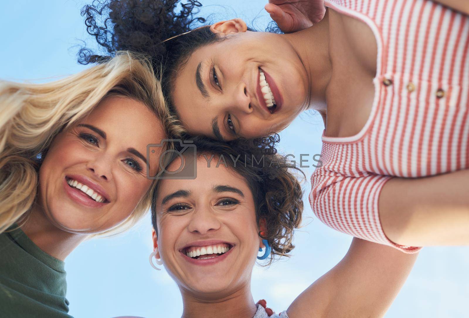 Shot of three female friends smiling down at the camera.