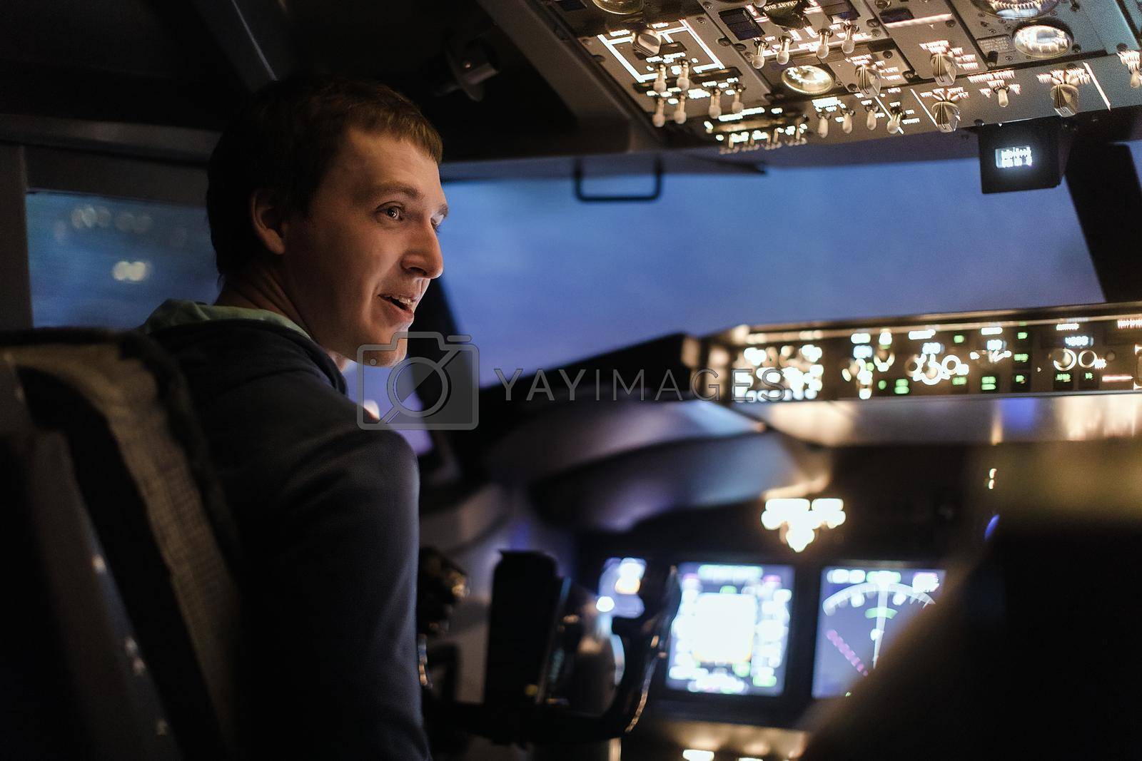 Young man piloting a plane in flight simulator for the training of the pilots
