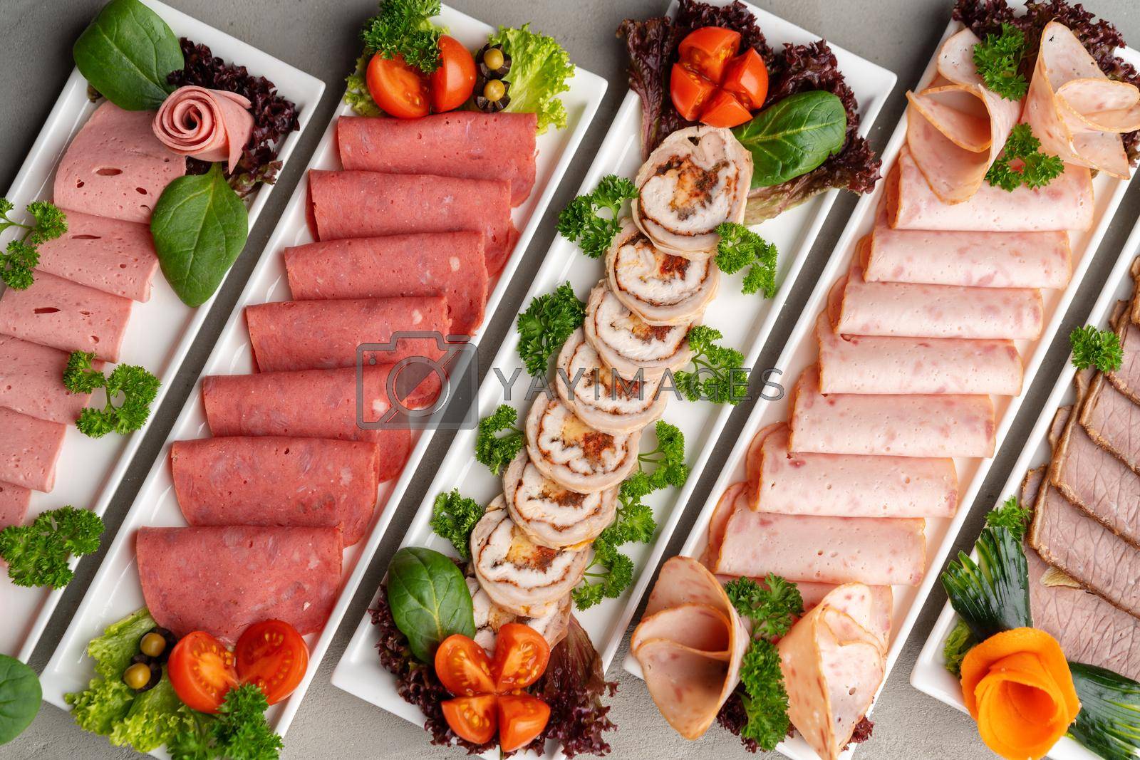 Royalty free image of Platter of fresh meat cold cuts on table by Fabrikasimf