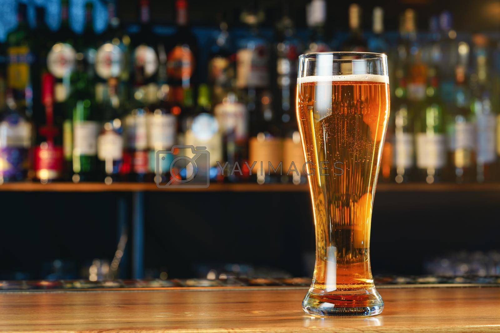 Royalty free image of Fresh cold beer in glass on bar background by Fabrikasimf