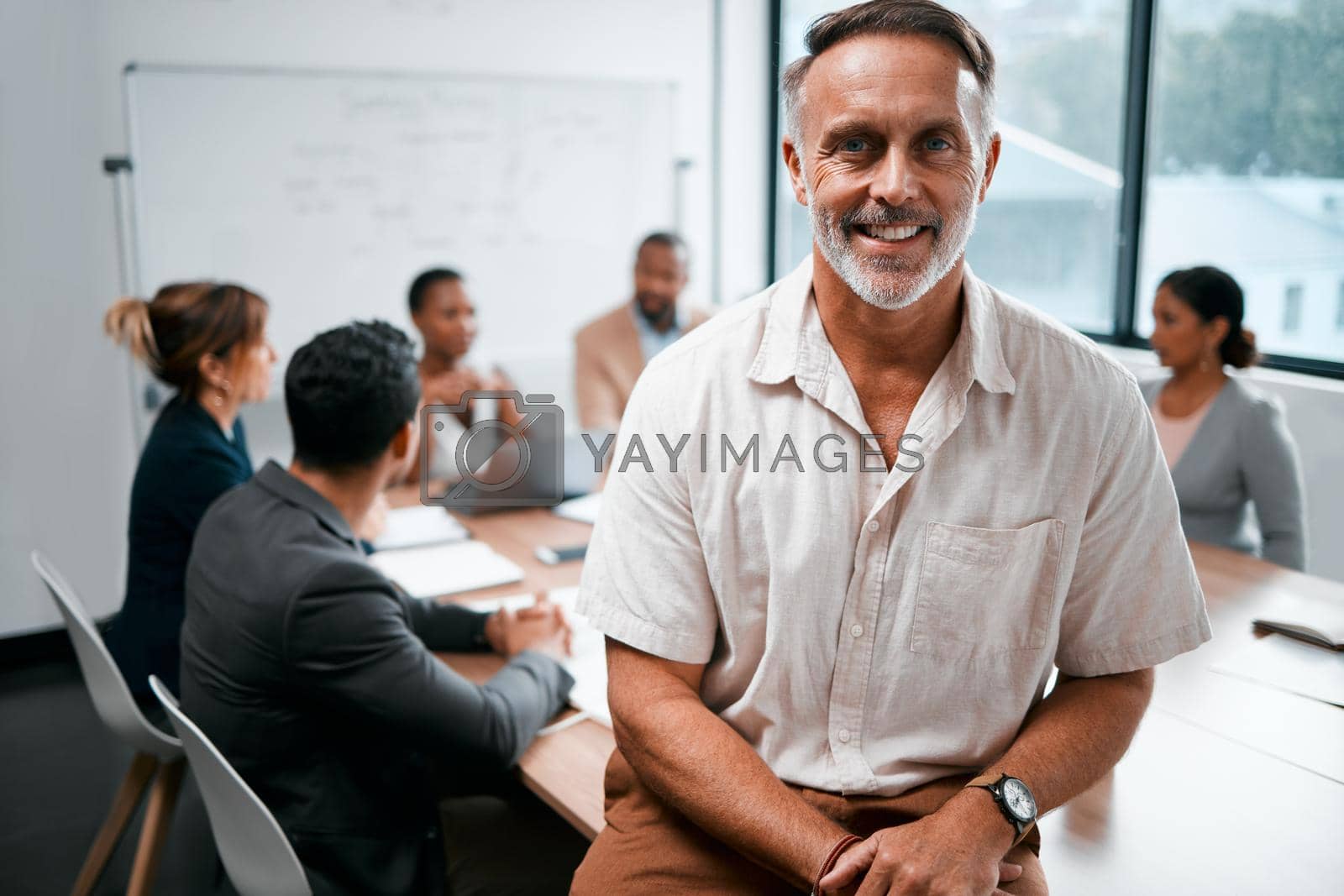 Royalty free image of Ive got an awesome team to work with. Cropped portrait of a handsome mature businessman attending a meeting in the boardroom with his colleagues in the background. by YuriArcurs