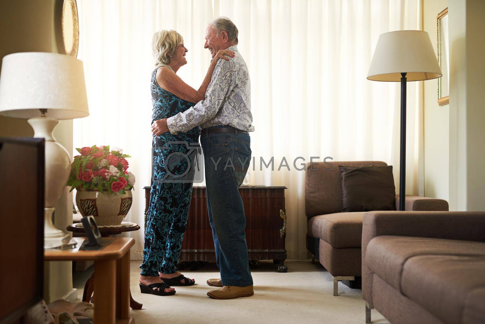 Shot of a happy senior couple dancing together at home.