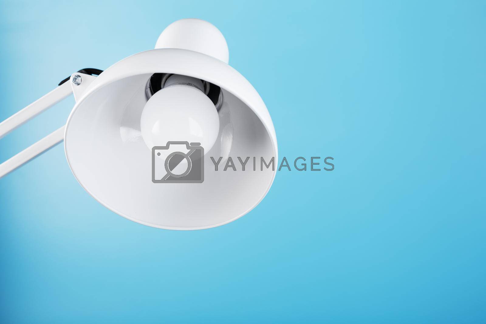 Office table lamp on blue background with space for text and idea concept