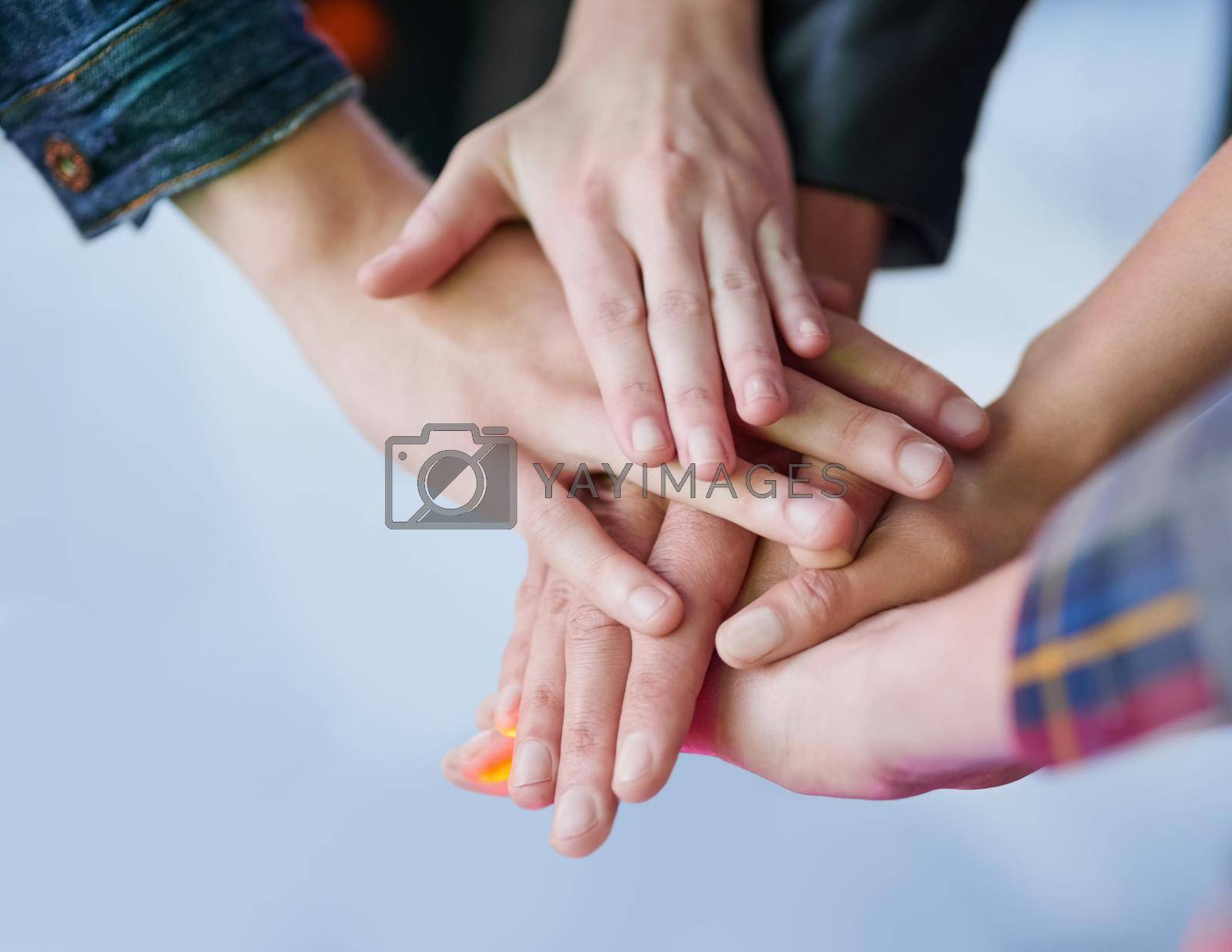 Royalty free image of Making a pact to stay friends forever. Shot of a group of unidentifiable friends making a pact by putting their hands in a pile. by YuriArcurs