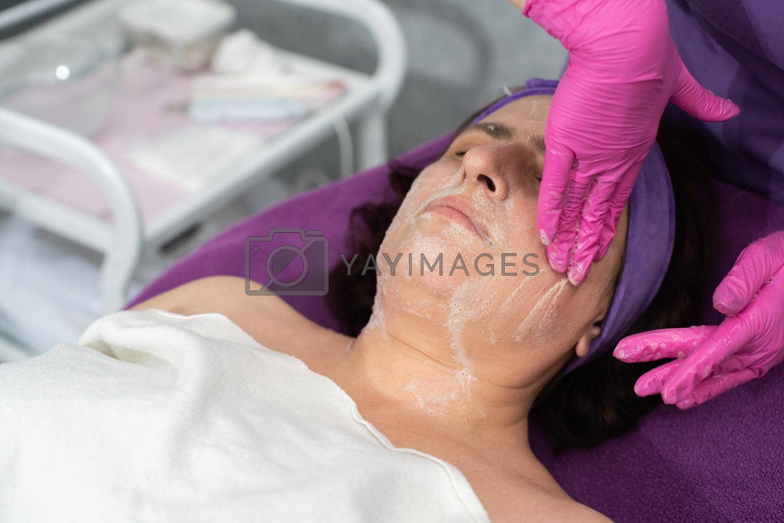 Royalty free image of Make-up removal with a special face cleansing gel is performed by a beautician. by fotodrobik