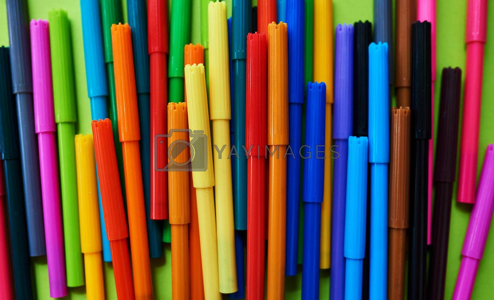 Royalty free image of Colour speaks louder than words. Studio shot of different coloured felt tip pens against a green background. by YuriArcurs