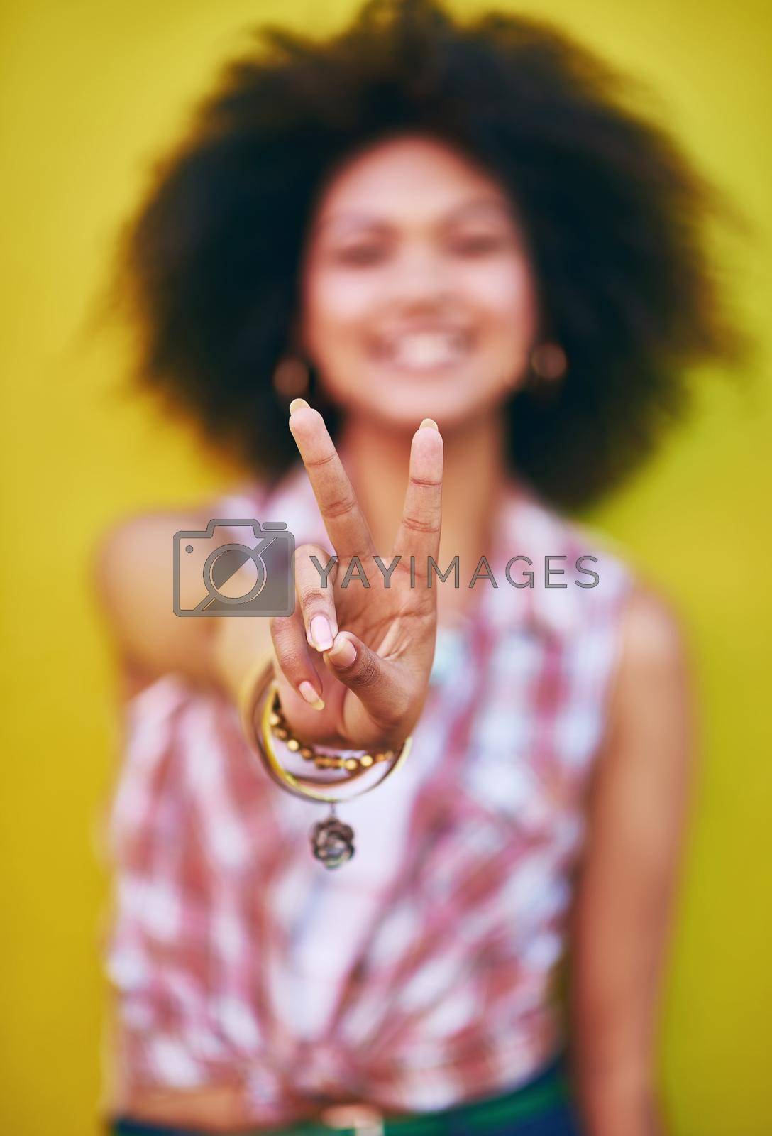 Closeup shot of a young woman showing the peace sign.