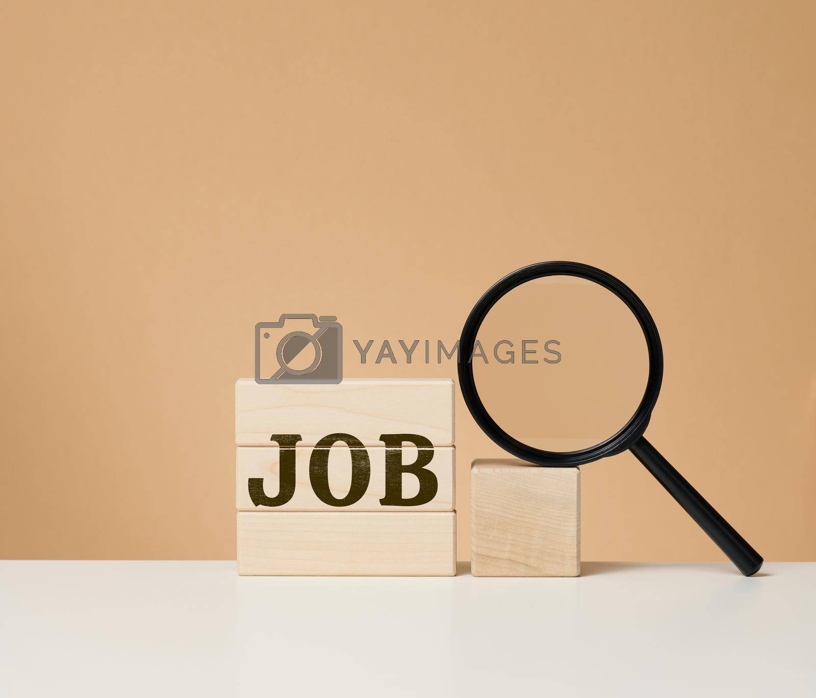 Royalty free image of Wooden cubes with the inscription work and a black magnifier on a white table. Job search, unemployment by ndanko